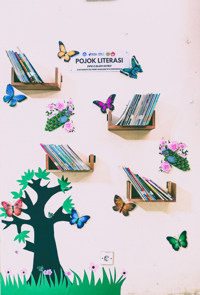 MAHASISWA PENDIDIKAN PROFESI GURU, UNIVERSITAS PGRI MAHADEWA BANTU WUJUDKAN POJOK LITERASI DI KANTOR DESA ANGANTAKA